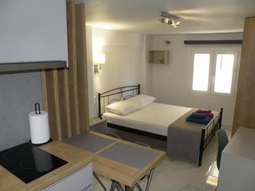 una piccola camera con letto e piccola cucina di Talos apartments and studios a Heraklion