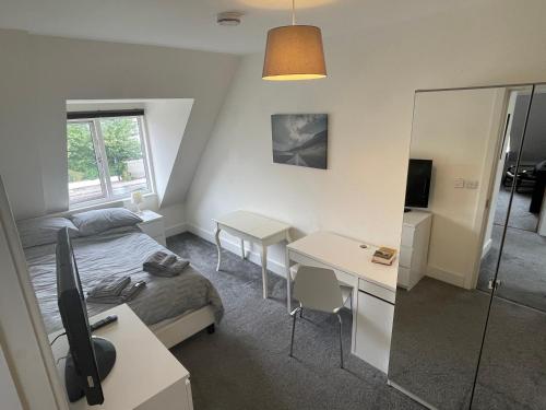 a bedroom with a bed and a desk and a mirror at 2 Bedroom 2 bathroom Apartment 8 including free parking in Bromley