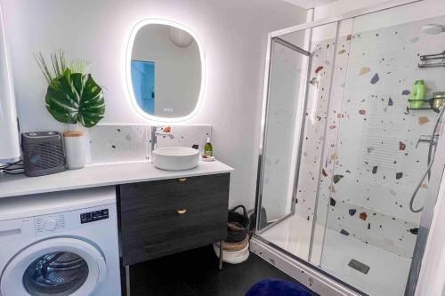 y baño con ducha y lavadora. en Le nid d'or lumineux, Clamart, Paris, en Clamart