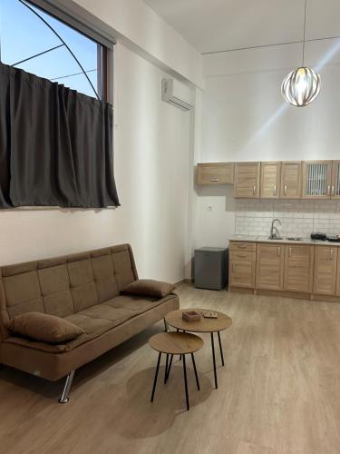 ein Wohnzimmer mit einem Sofa und einem Tisch in der Unterkunft Paola’s apartments near Athens Airport in Spáta