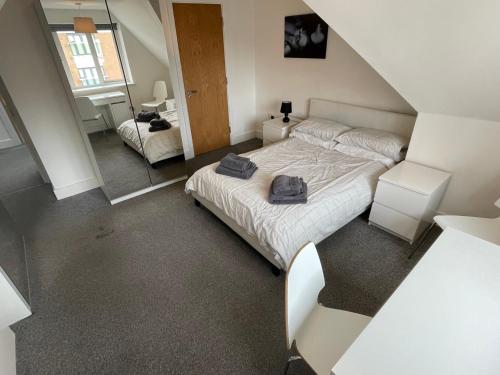 a bedroom with a large bed and a mirror at 2 Bedroom 2 bathroom Apartment 8 including free parking in Bromley