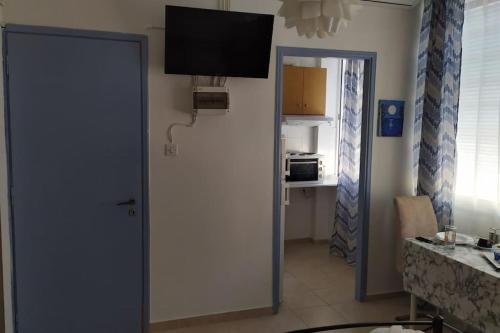a room with a door with a television on the wall at Κεντρικό στούντιο στην Καρδίτσα. in Kardítsa