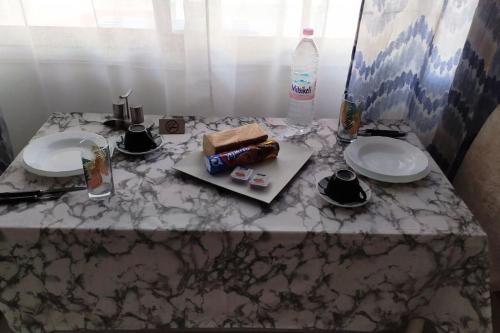 a table with two plates and a bottle of water at Κεντρικό στούντιο στην Καρδίτσα. in Karditsa