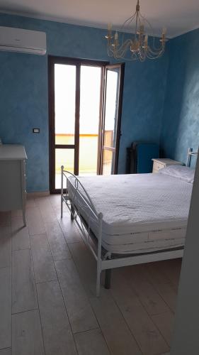- une chambre avec un lit dans une pièce aux murs bleus dans l'établissement Residence 3, à Montauro