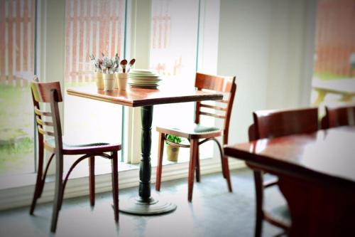 a dining room table with chairs and a table with plates at Piece of Hjo Vandrarhem in Hjo