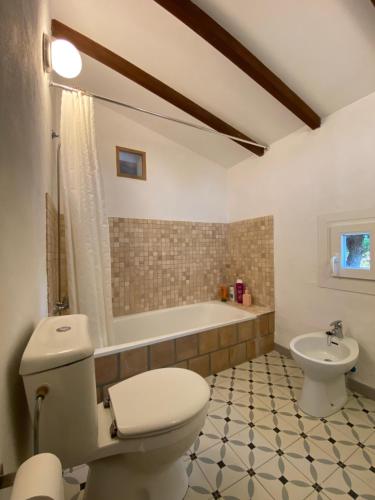 a bathroom with a toilet and a tub and a sink at Finca es Born - vistas panorámicas in Esporles