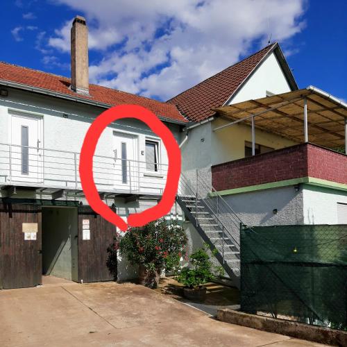 a house with a red circle in front of it at Engelhard´s Ferien Apartment in Hillesheim