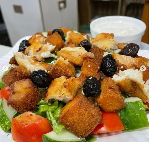 a plate of food with a salad with chicken and olives at Portland Resort Hotel in Port Harcourt