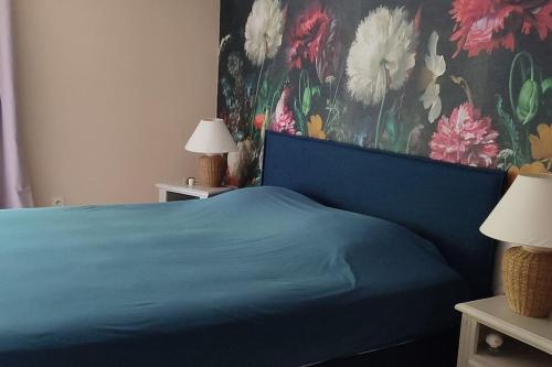 1 dormitorio con cama azul y papel pintado con motivos florales en Mas du Vieux Moulin, en Sérignan-du-Comtat