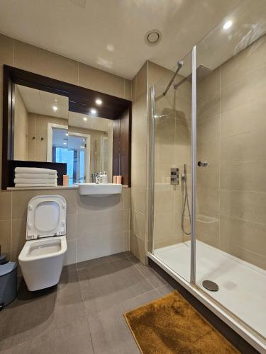 y baño con ducha, aseo y lavamanos. en 2 bed Luxurious apartments Canary Wharf en Londres