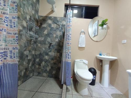 a bathroom with a shower and a toilet and a sink at Arenal Memories. in Fortuna