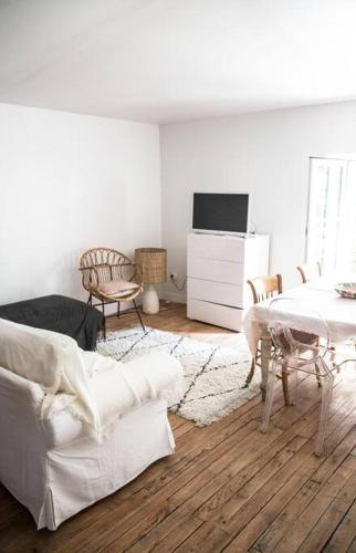 un salon avec un canapé blanc et une table dans l'établissement Villa Séquoia - Grande Chambre SDB & cuisine privées, à Bazas