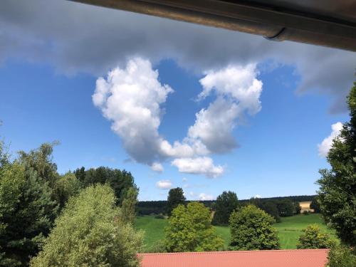 a heart shaped cloud in the sky over a field at Loft im Haus mit Geschichte in Mähring