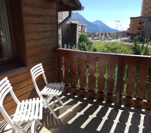 two white chairs sitting on a porch with a view at Chalet d'Orcières T2 4pers. in Orcières