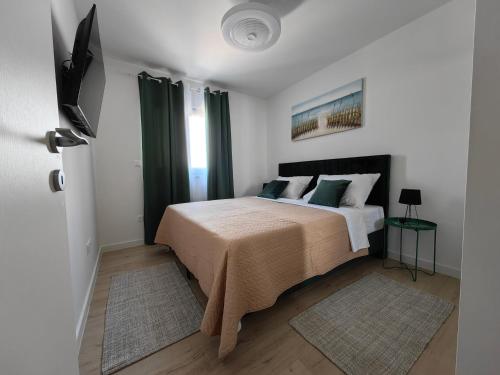 a bedroom with a large bed with green curtains at Apartments SORELLE in Podstrana