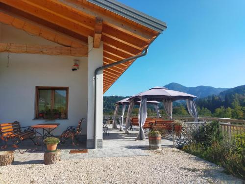 a patio with a table and an umbrella at Agritur Maso Flonkeri in Bosentino