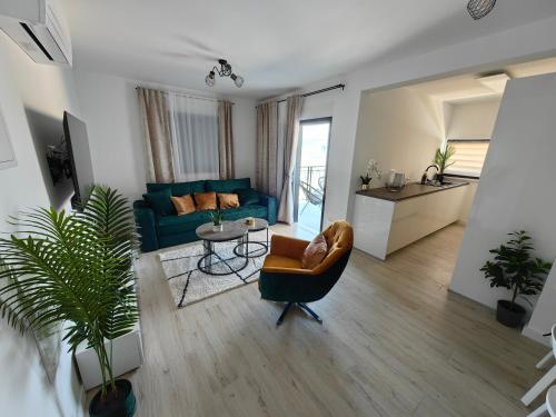 uma sala de estar com um sofá azul e uma cadeira em Apartments SORELLE em Podstrana