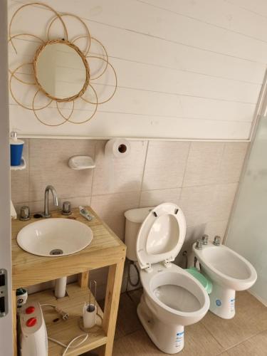 een badkamer met een toilet, een wastafel en een spiegel bij Cabaña La Querida in Santa Rosa