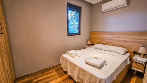 a bedroom with a bed with white sheets and a window at Elasu Bodrum in Bodrum City