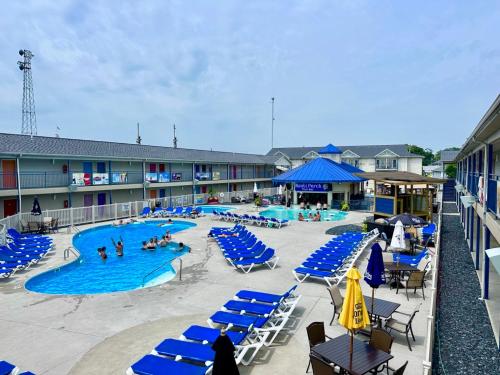 a pool with blue chairs and people in a hotel at Islander Inn in Put-in-Bay