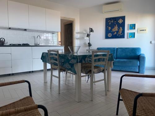 cocina y comedor con mesa y sillas en A Punta Tegge il mare la spiaggia il tramonto, en La Maddalena