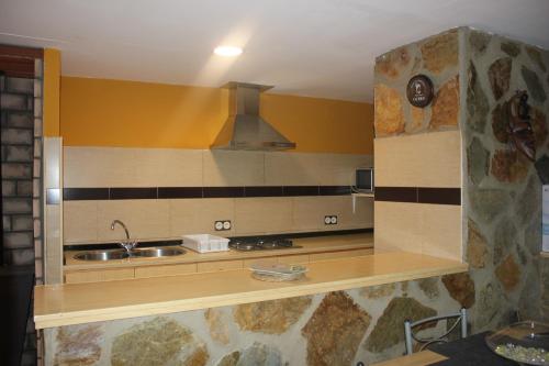 a kitchen with a sink and a stove at Casa Vacacional El Cañizo in Córdoba