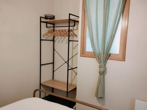 - une chambre avec une fenêtre et un rideau dans l'établissement Les Granges des Petits Couleurs, aux Épesses