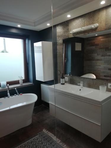 a bathroom with a tub and a large mirror at Mrągowo Pokoje Apartament in Mrągowo