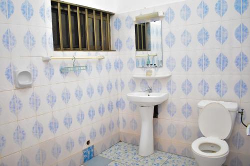 uma casa de banho azul e branca com um WC e um lavatório em Chez mimi em Cotonou