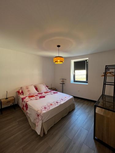 1 dormitorio con cama con sábanas rosas y ventana en La Patafiole Appartement T2 calme élégant en Pont-de-Barret