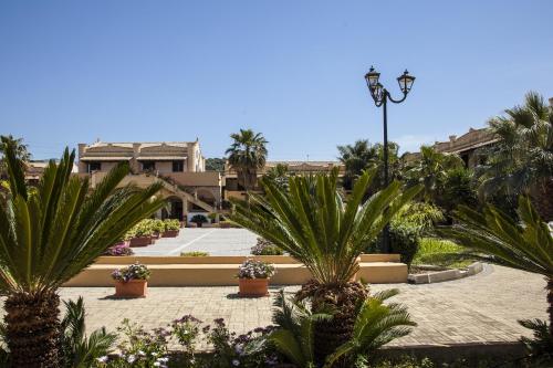 a courtyard with palm trees and a street light at Borgomare in Campofelice di Roccella