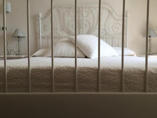 a bed with white sheets and pillows in a bedroom at Hotel Villa San Fedele in San Fedele Intelvi