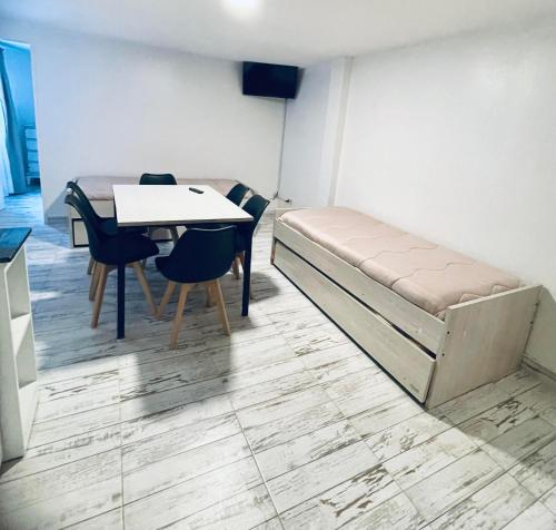 Antu Mahuida Apartments في سان كارلوس دي باريلوتشي: غرفة بسرير وطاولة وكراسي