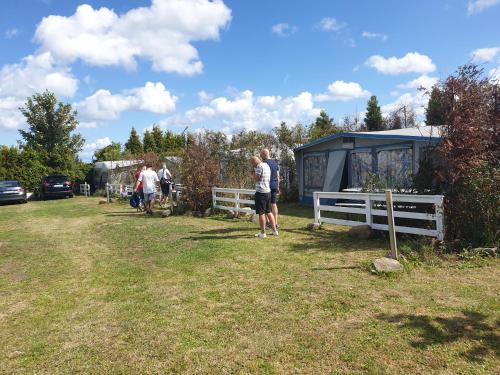 a group of people standing in a field next to a trailer at Camping - Park Władysławowo in Władysławowo