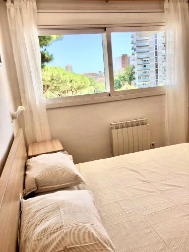 um quarto com 2 camas e uma grande janela em Apartamento familiar con piscina y ubicación ideal em Platja d'Aro