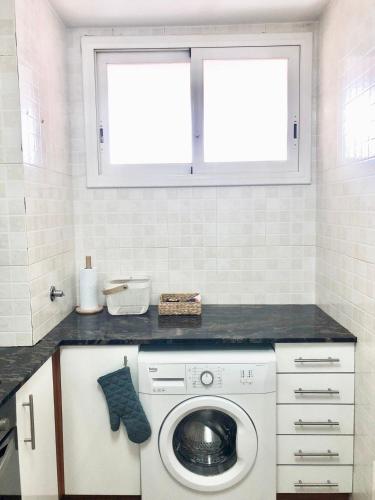 uma máquina de lavar roupa numa cozinha com uma janela em Apartamento familiar con piscina y ubicación ideal em Platja d'Aro