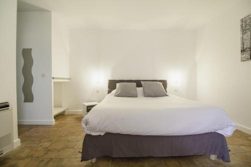 a bedroom with a large bed with white sheets at Domaine Du Val De Cèze in Bagnols-sur-Cèze