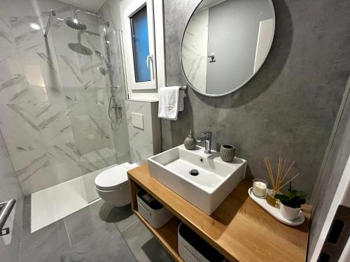 W łazience znajduje się umywalka, toaleta i lustro. w obiekcie Premium mobile home Eden w mieście Velenje