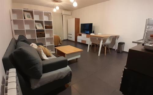 een woonkamer met een bank en een tafel bij Cálido depto 2 personas- Zona residencial in Morón