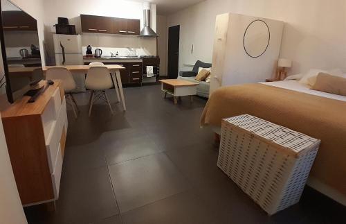 a bedroom with a bed and a kitchen and a room with at Cálido depto 2 personas- Zona residencial in Morón