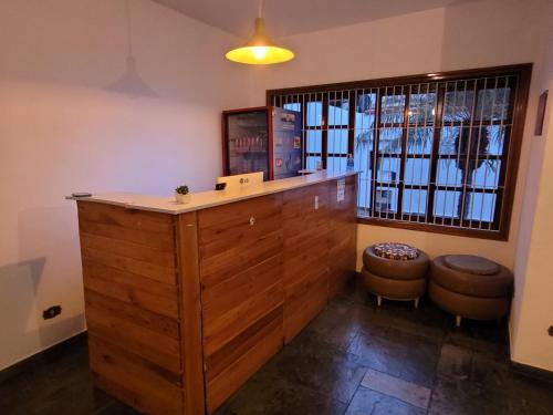 a large wooden counter in a room with a window at Hostel BoituVillage in Boituva