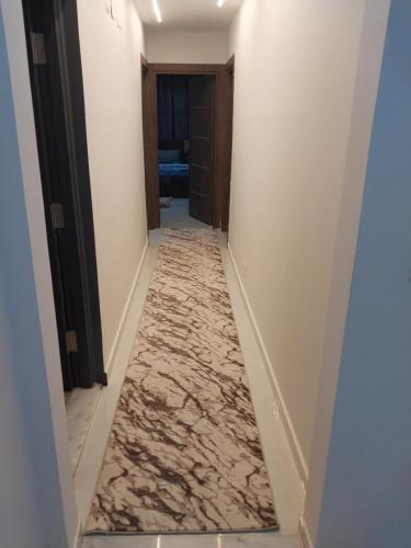 a hallway with marble flooring in a hotel room at شقه مفروش in Madinaty