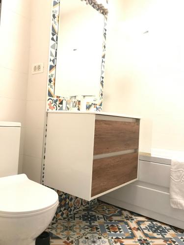 a bathroom with a toilet and a mirror at Orange Onix Apartaments in Bucharest