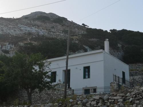 a white house on a hill with a mountain at Με θέα το χωριό & το όρος Ζευς! in Apeiranthos