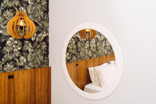 a mirror in a hotel room with a chair and a couch at Cris Hotel in Florianópolis