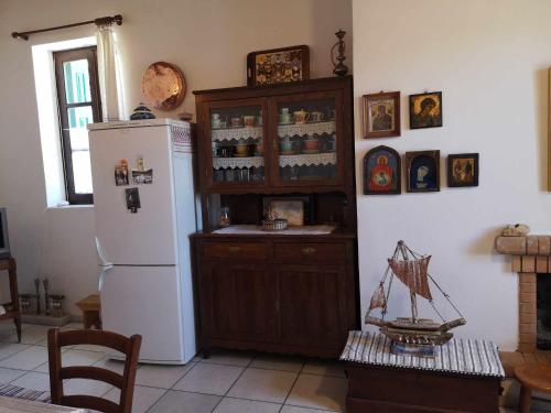 a kitchen with a refrigerator and a table with a toy boat at Με θέα το χωριό & το όρος Ζευς! in Apeiranthos