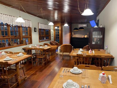 ein Esszimmer mit Holztischen und -stühlen in der Unterkunft Pousada Villa Cantaloa in Gramado