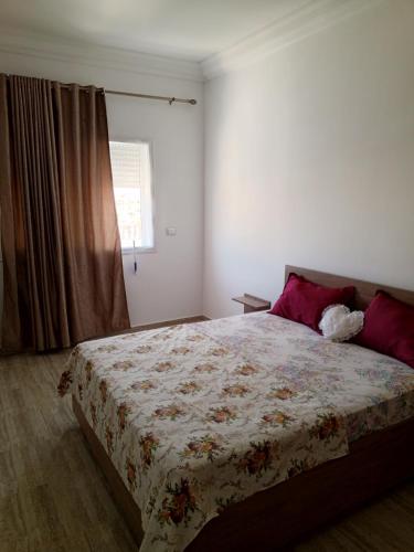 a bedroom with a large bed with a floral blanket at Vue sur mer, 3 chambres, Construit en 2024, in Sousse