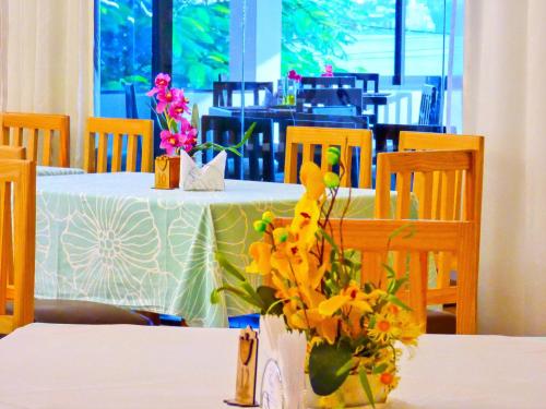 a table with a white table with flowers on it at De La Costa Hotel in Encarnación