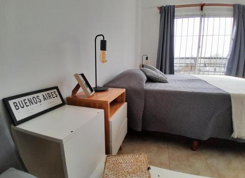 Schlafzimmer mit einem Bett, einem Schreibtisch und einem Fenster in der Unterkunft Luminoso depto 2 o 3 personas Zona residencial in Morón